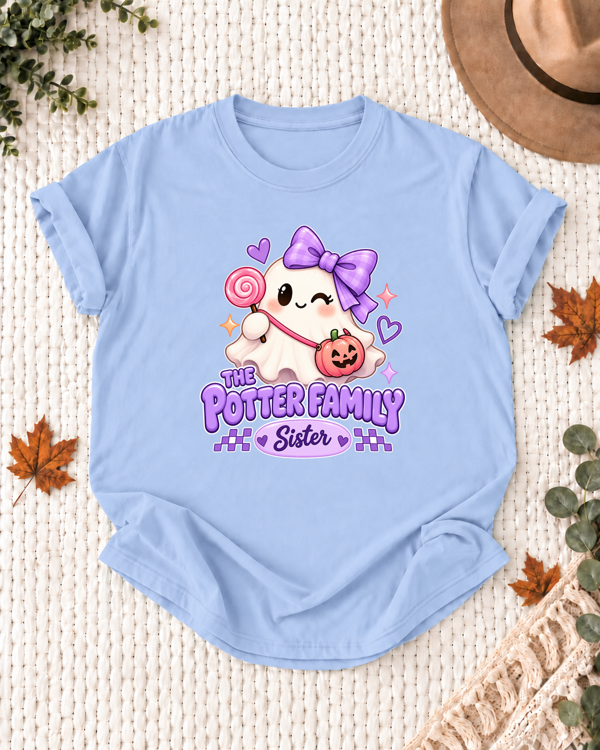Sister's Light Blue personalized Halloween shirt mockup with a ghost with a purple bow, lollipop, and pumpkin bag, sample family lettering, and the role label.