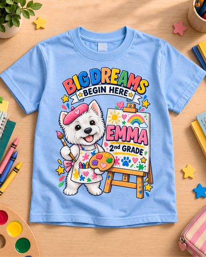 Light blue personalized second grade artist dog youth shirt flat lay with the sample name Emma.