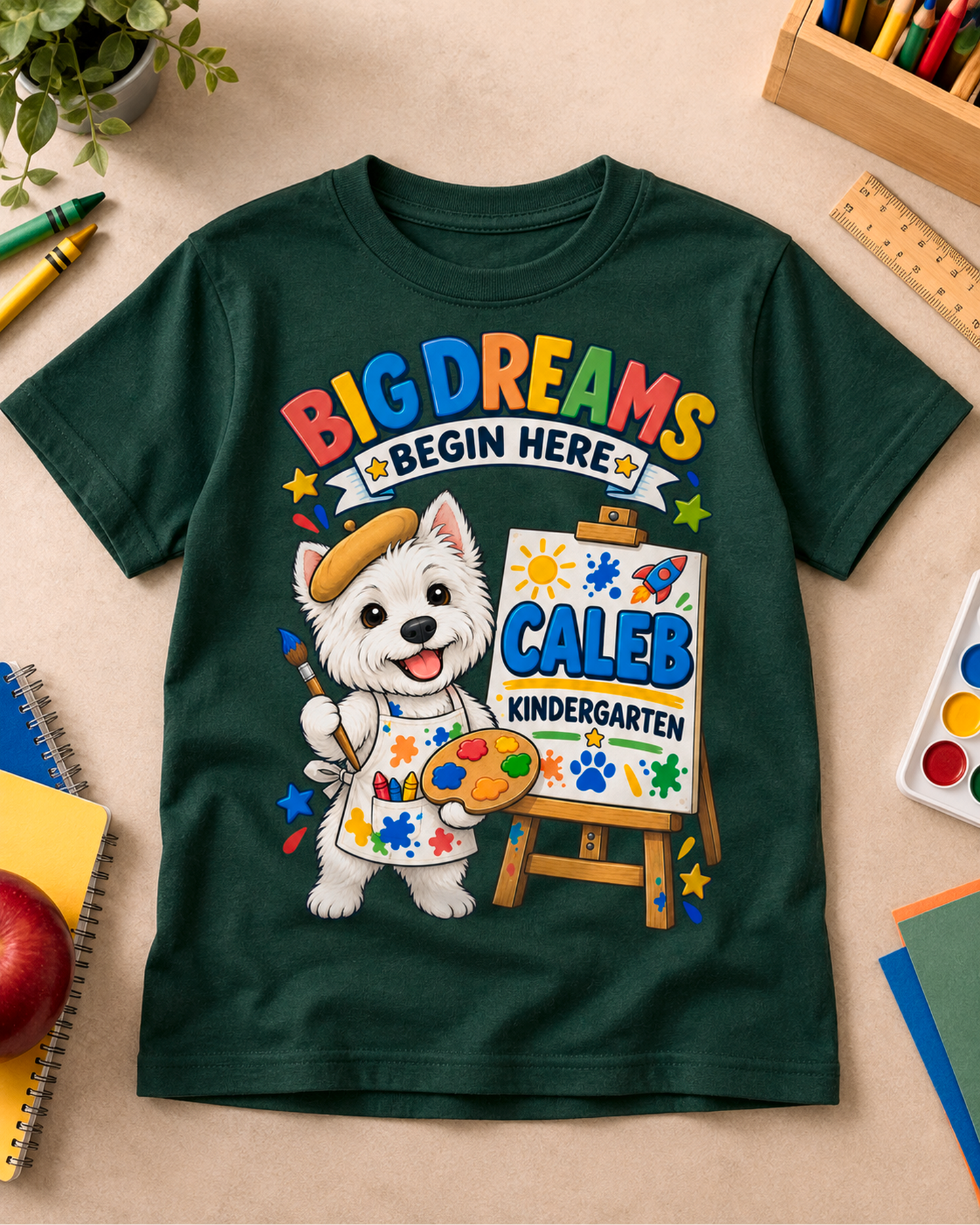 Forest green personalized kindergarten artist dog youth shirt flat lay with the sample name Caleb.