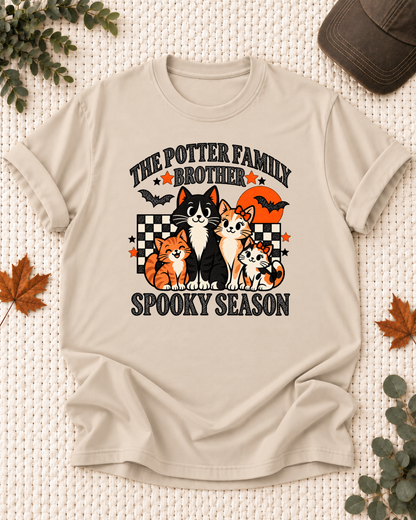 Sand Brother T-shirt with four illustrated cats, an orange moon, bats, black-and-cream checkerboard accents, jack-o'-lanterns, and example family-name text.