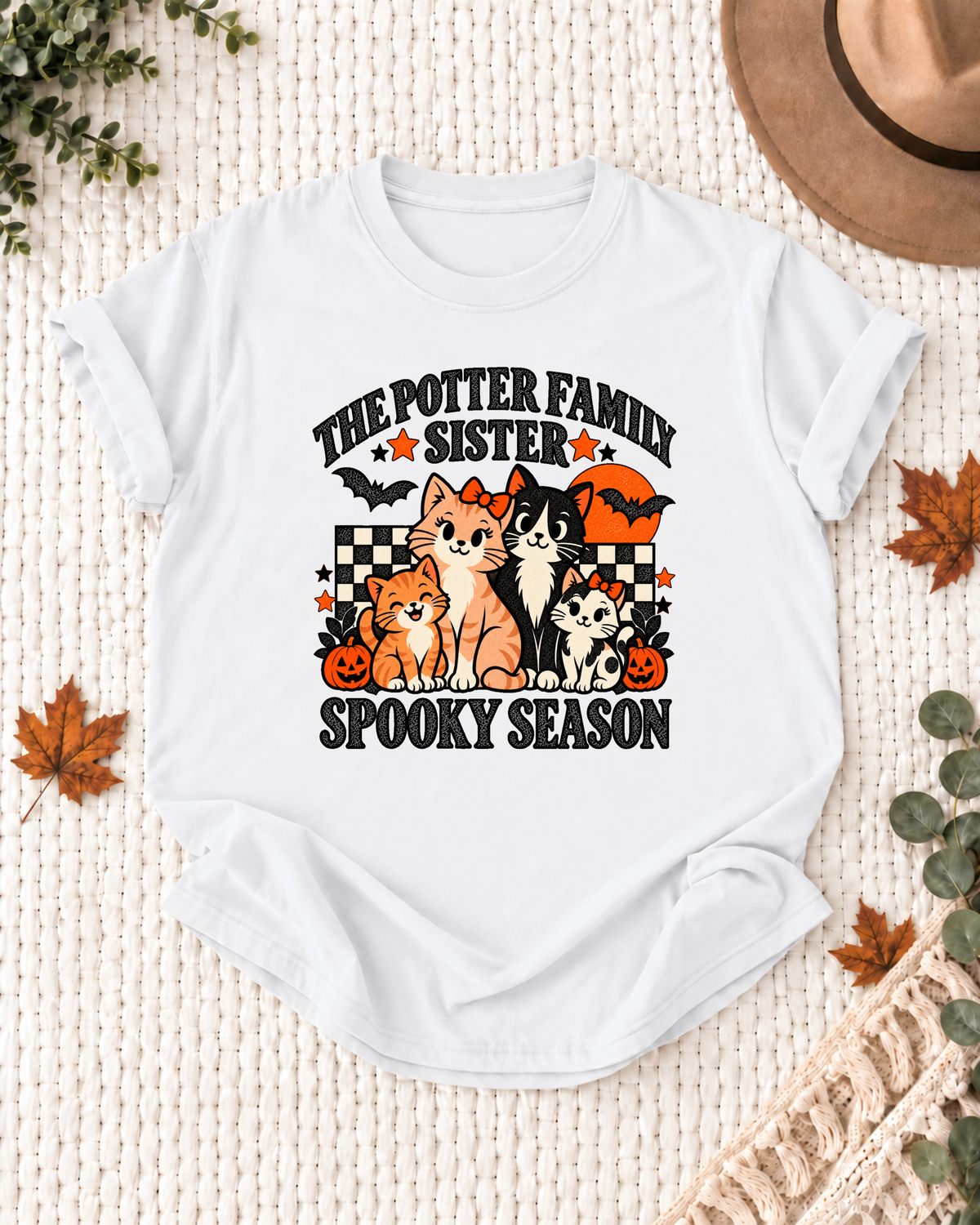 White Sister T-shirt with four illustrated cats, an orange moon, bats, black-and-cream checkerboard accents, jack-o'-lanterns, and example family-name text.