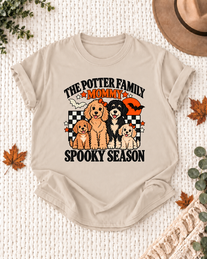 Sand Mommy T-shirt with four illustrated dogs, an orange moon, bats, black-and-cream checkerboard accents, and example family-name text.