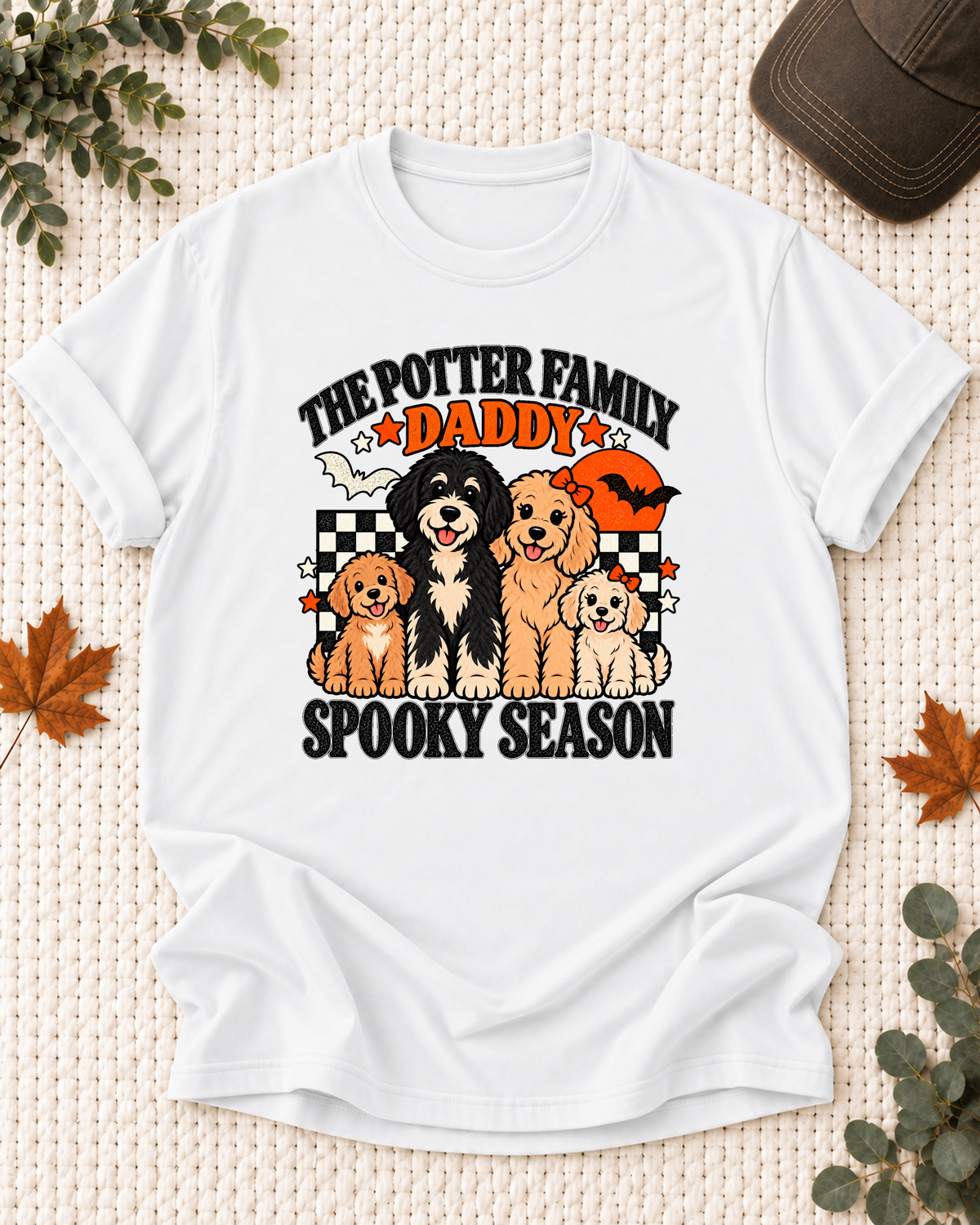 White Daddy T-shirt with four illustrated dogs, an orange moon, bats, black-and-cream checkerboard accents, and example family-name text.