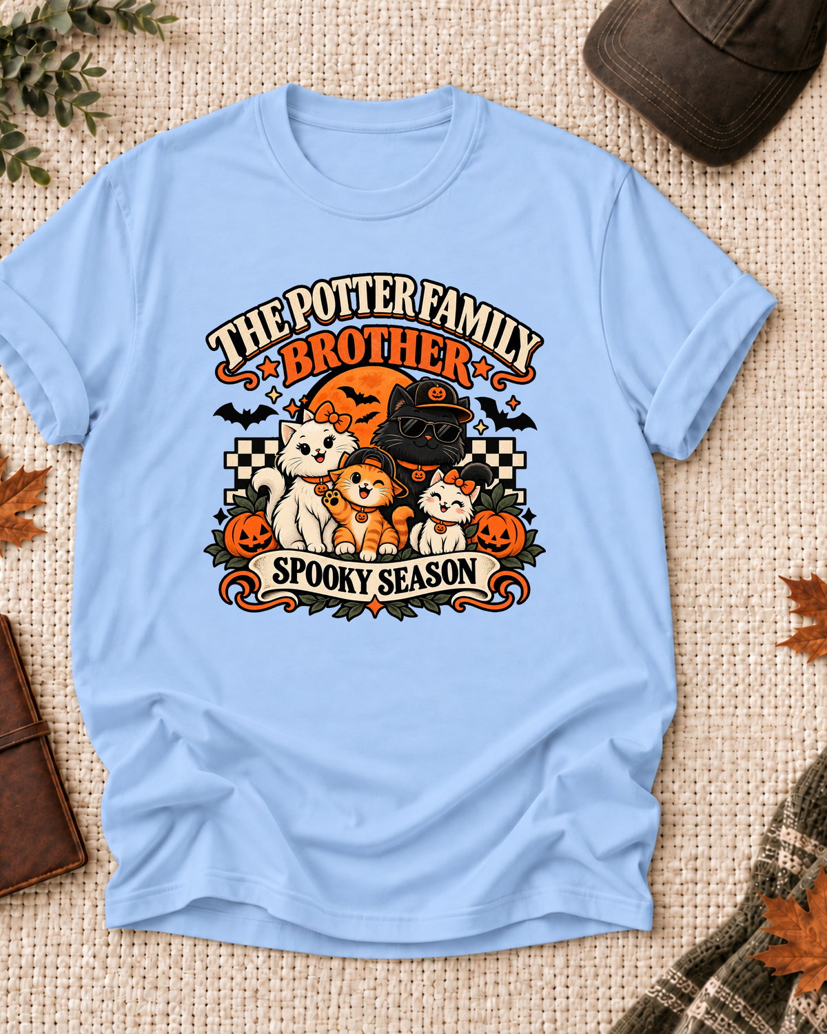 Light blue Brother T-shirt with costume-inspired cats, including a black cat in a pumpkin cap and sunglasses, with example family-name text.