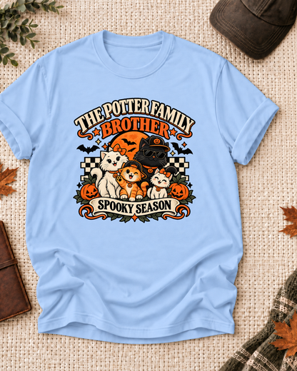 Light blue Brother T-shirt with costume-inspired cats, including a black cat in a pumpkin cap and sunglasses, with example family-name text.