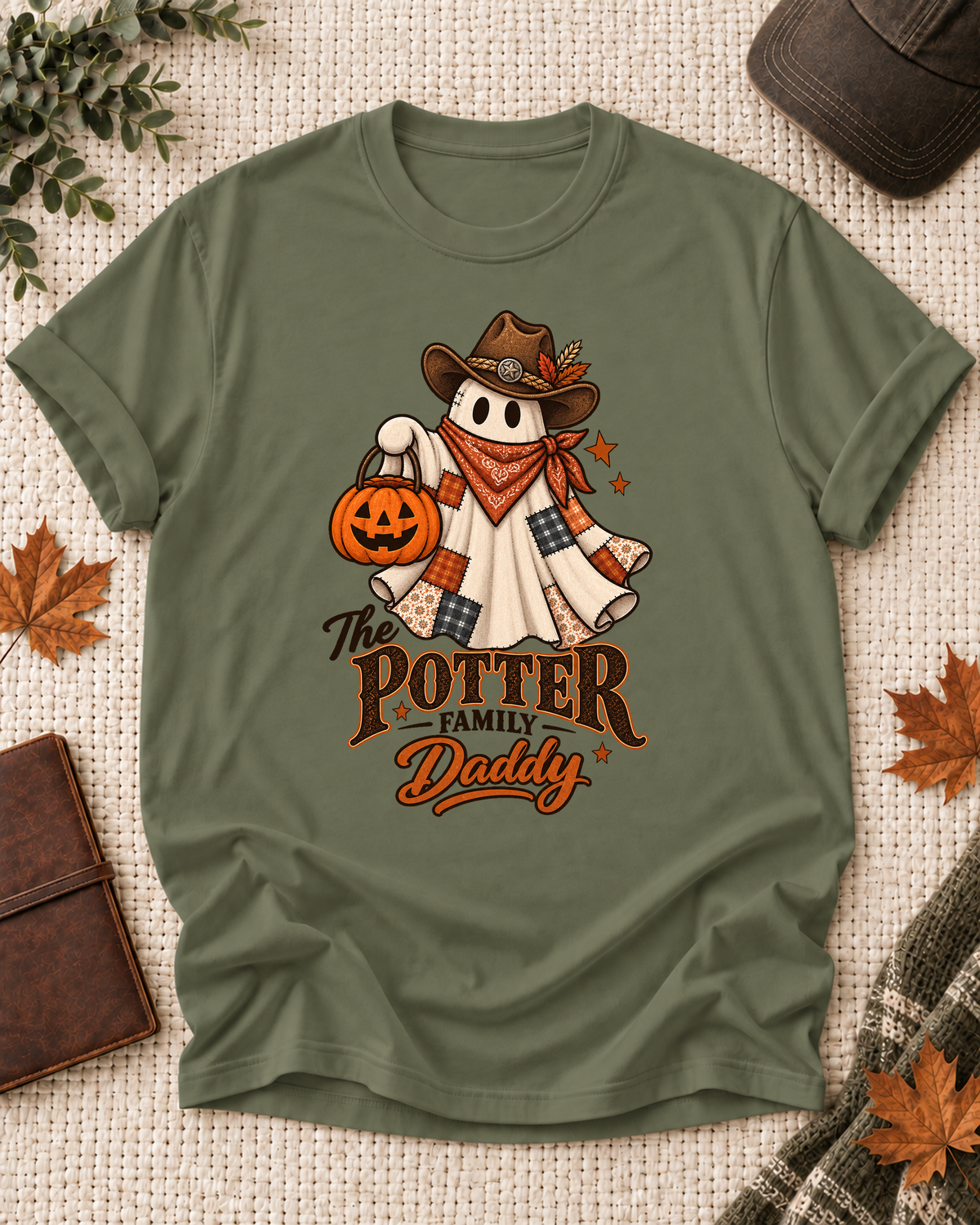 Olive Daddy T-shirt with a patchwork ghost wearing a cowboy hat and scarf, holding a jack-o'-lantern, with example family-name text.