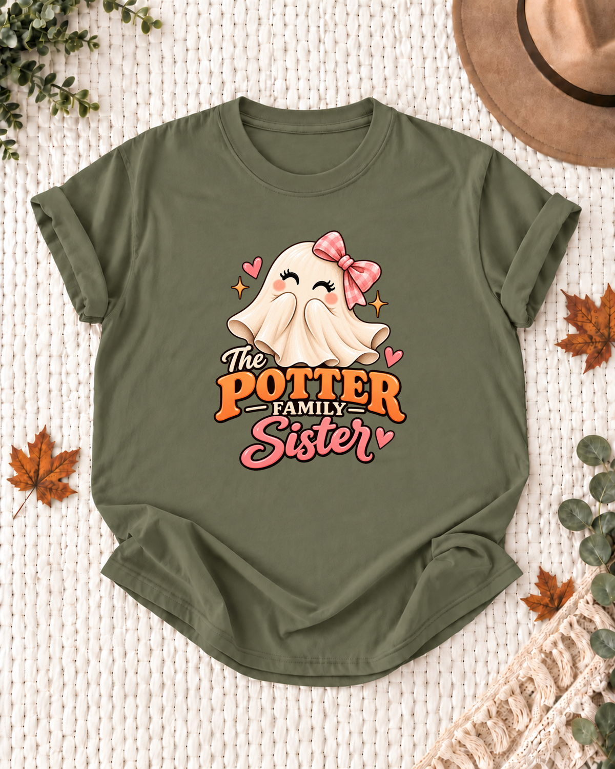 Sister's Olive personalized Halloween shirt mockup with a smiling ghost with a pink bow and heart accents, sample family lettering, and the role label.