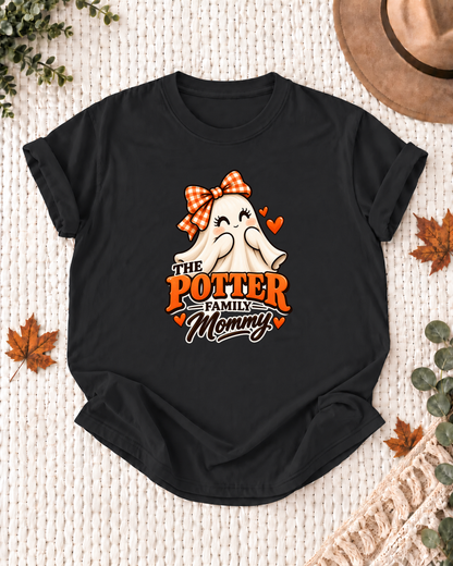 Mommy's Black personalized Halloween shirt mockup with a smiling ghost with an orange bow and hearts, sample family lettering, and the role label.