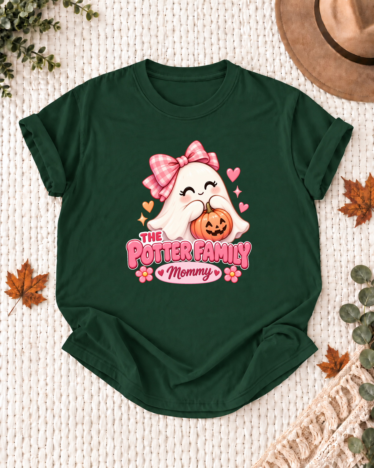 Mommy's Dark Green personalized Halloween shirt mockup with a ghost with a pink bow, pumpkin, and flowers, sample family lettering, and the role label.