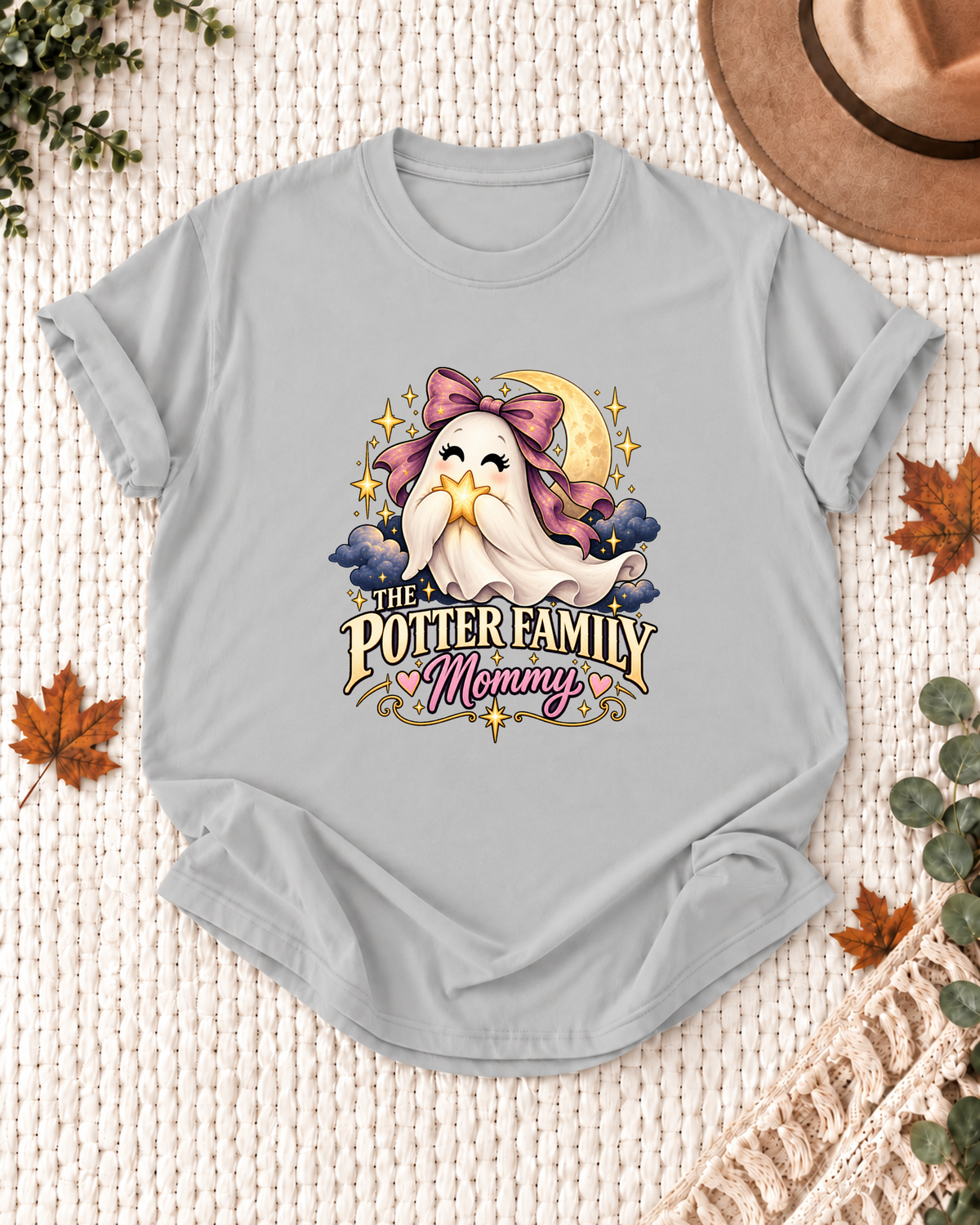Mommy's Ash Grey personalized Halloween shirt mockup with a ghost with a purple bow, star, and moon, sample family lettering, and the role label.