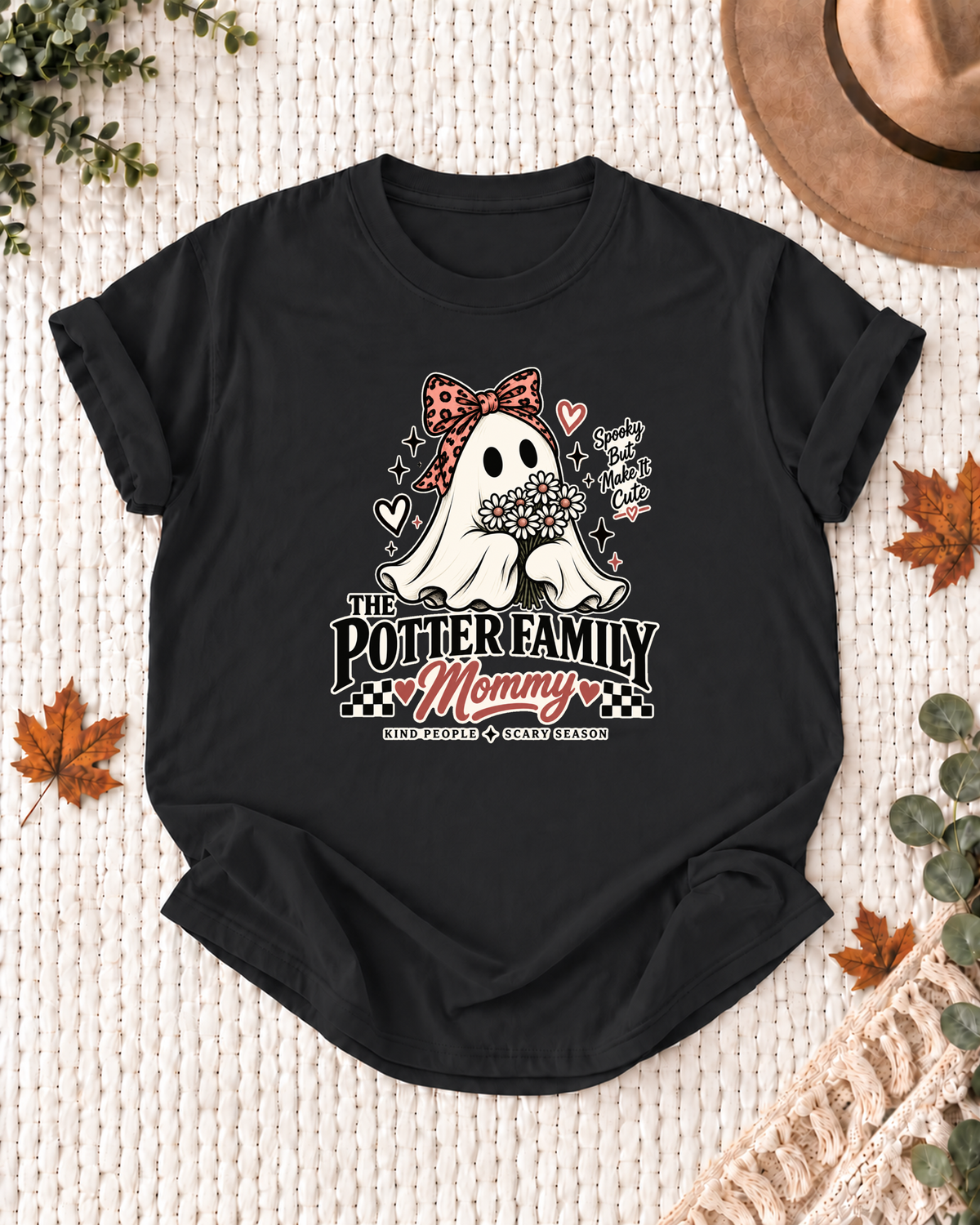 Mommy's Black personalized Halloween shirt mockup with a line-art ghost with a patterned bow and floral accents, sample family lettering, and the role label.