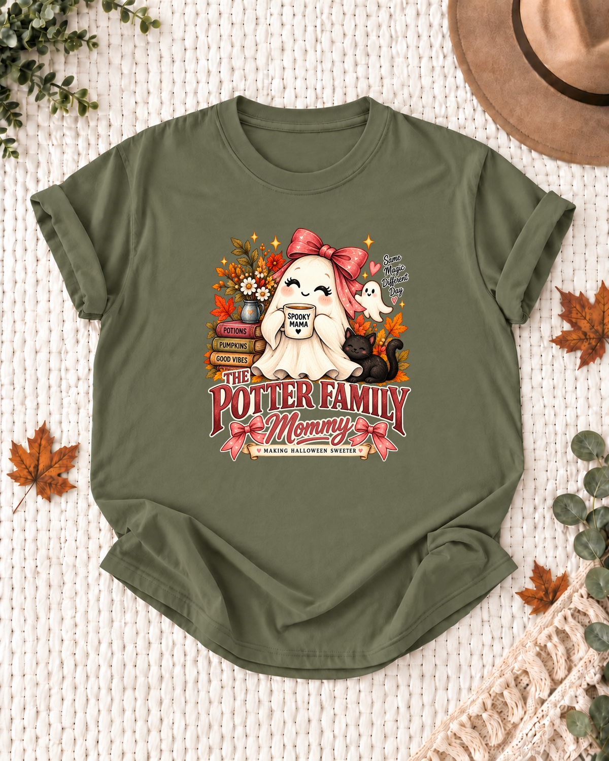 Mommy's Olive personalized Halloween shirt mockup with a ghost with a pink bow, black cat, and autumn accents, sample family lettering, and the role label.