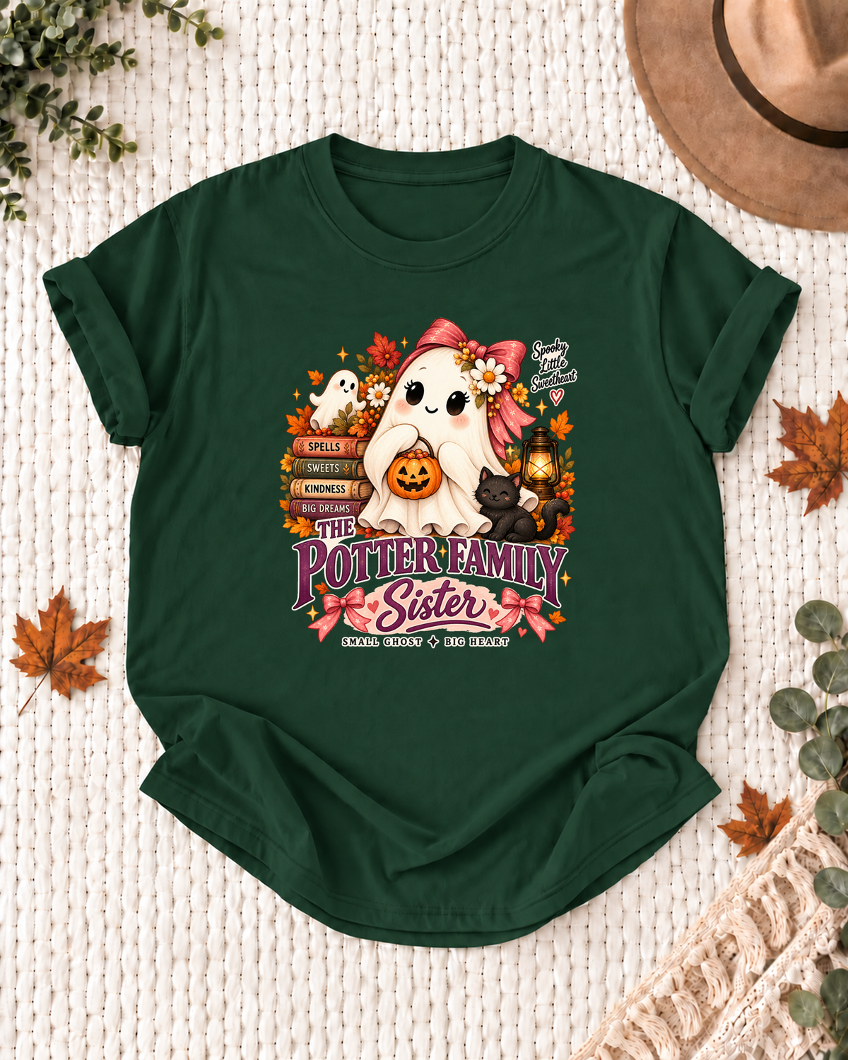 Sister's Dark Green personalized Halloween shirt mockup with a ghost with a pink bow, black cat, lantern, and pumpkin, sample family lettering, and the role label.