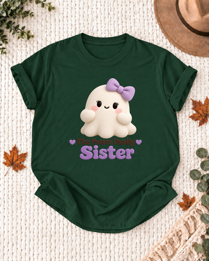 Sister's Dark Green personalized Halloween shirt mockup with a soft rounded ghost with a lavender bow, sample family lettering, and the role label.
