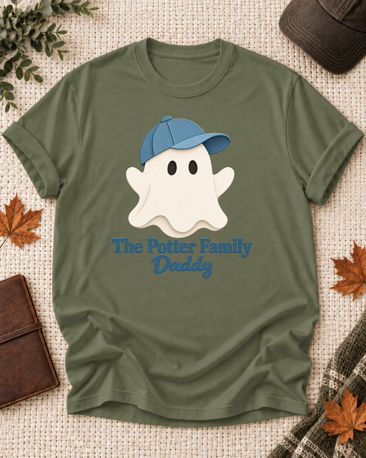 Daddy's Olive personalized Halloween shirt mockup with a minimal cream ghost with a blue cap, sample family lettering, and the role label.