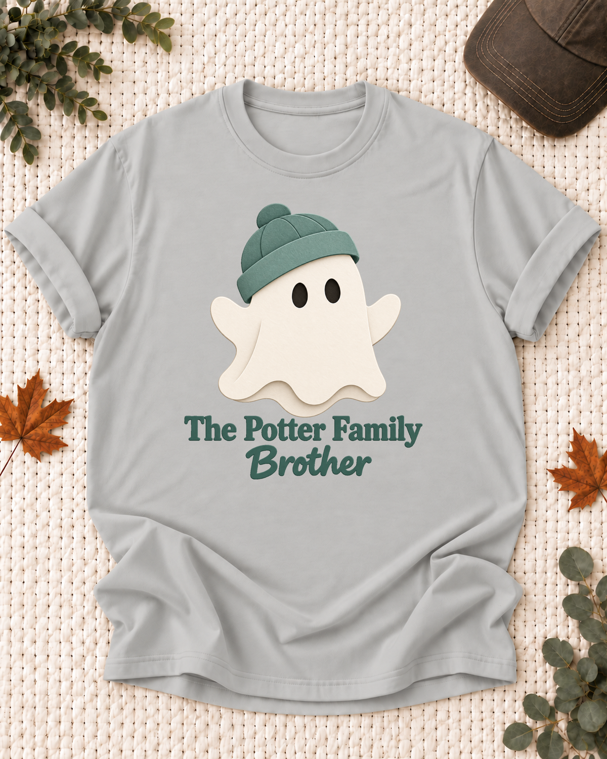 Brother's Ash Grey personalized Halloween shirt mockup with a minimal cream ghost with a green beanie, sample family lettering, and the role label.