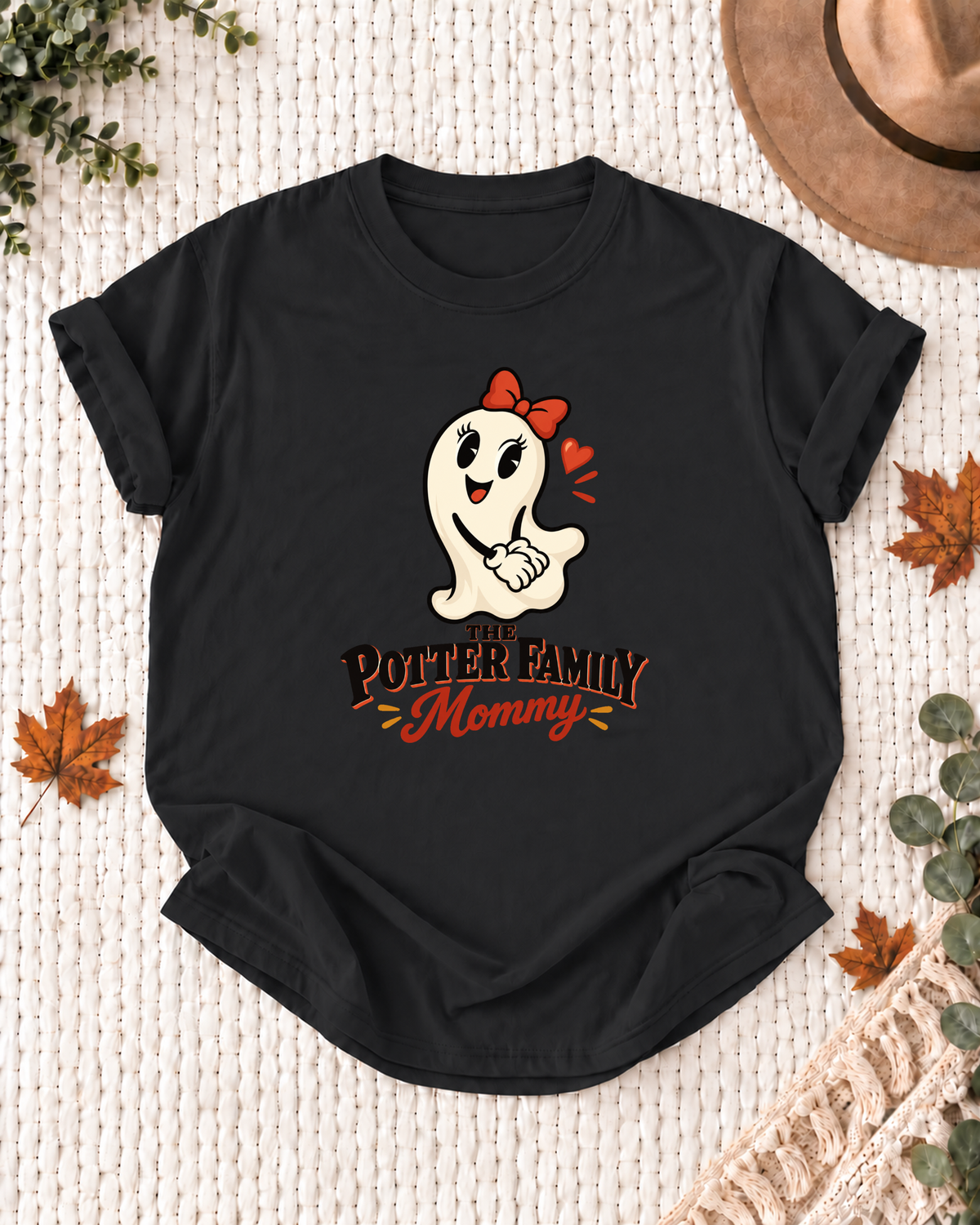 Mommy's Black personalized Halloween shirt mockup with a cartoon ghost with a red bow, sample family lettering, and the role label.