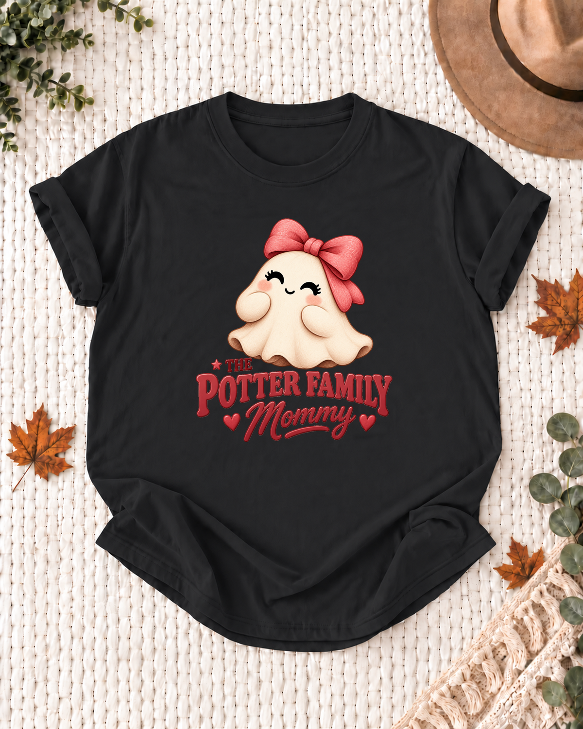 Mommy's Black personalized Halloween shirt mockup with a rounded ghost with a coral bow and hearts, sample family lettering, and the role label.