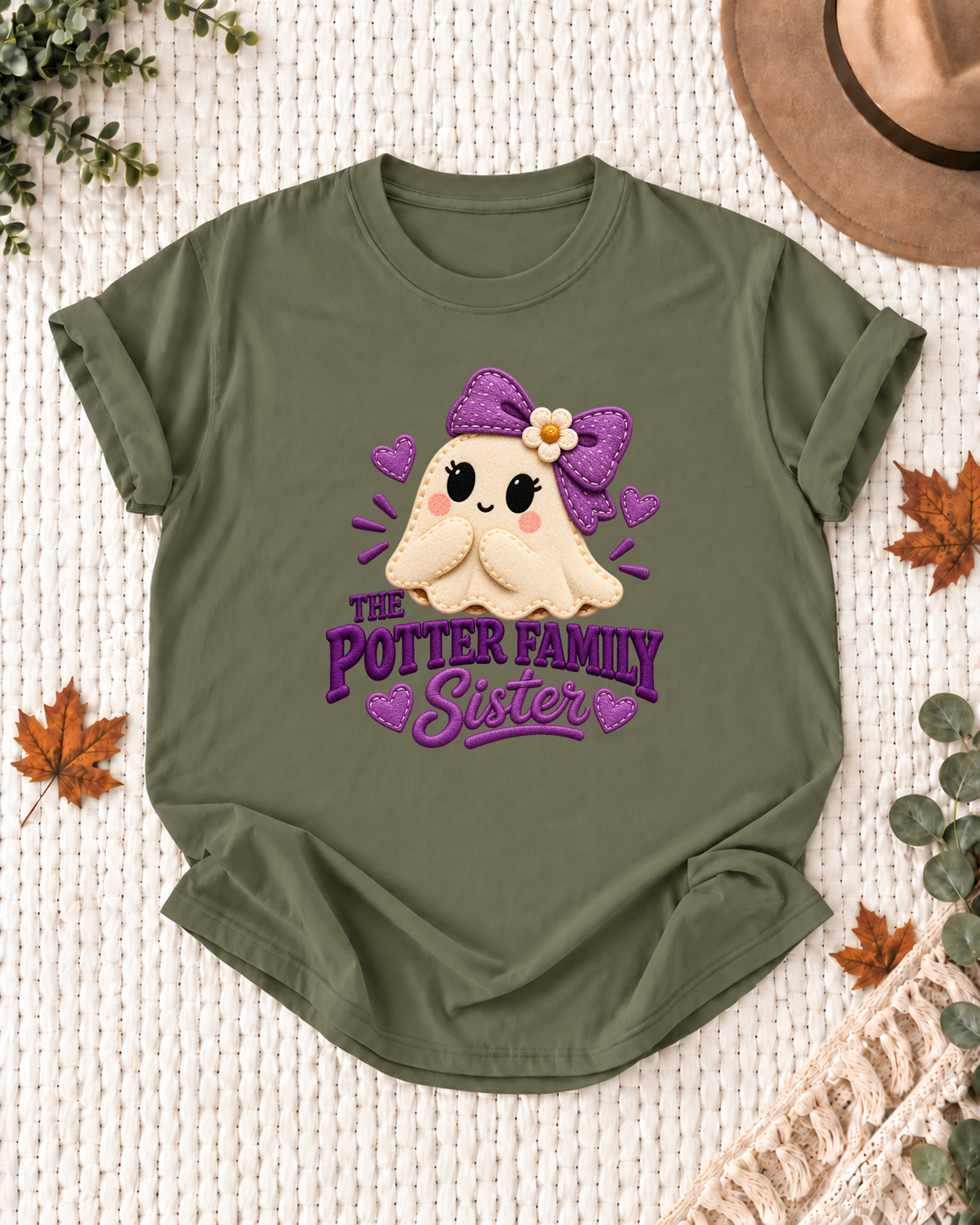 Sister's Olive personalized Halloween shirt mockup with a patchwork-style ghost with a purple bow and heart patches, sample family lettering, and the role label.