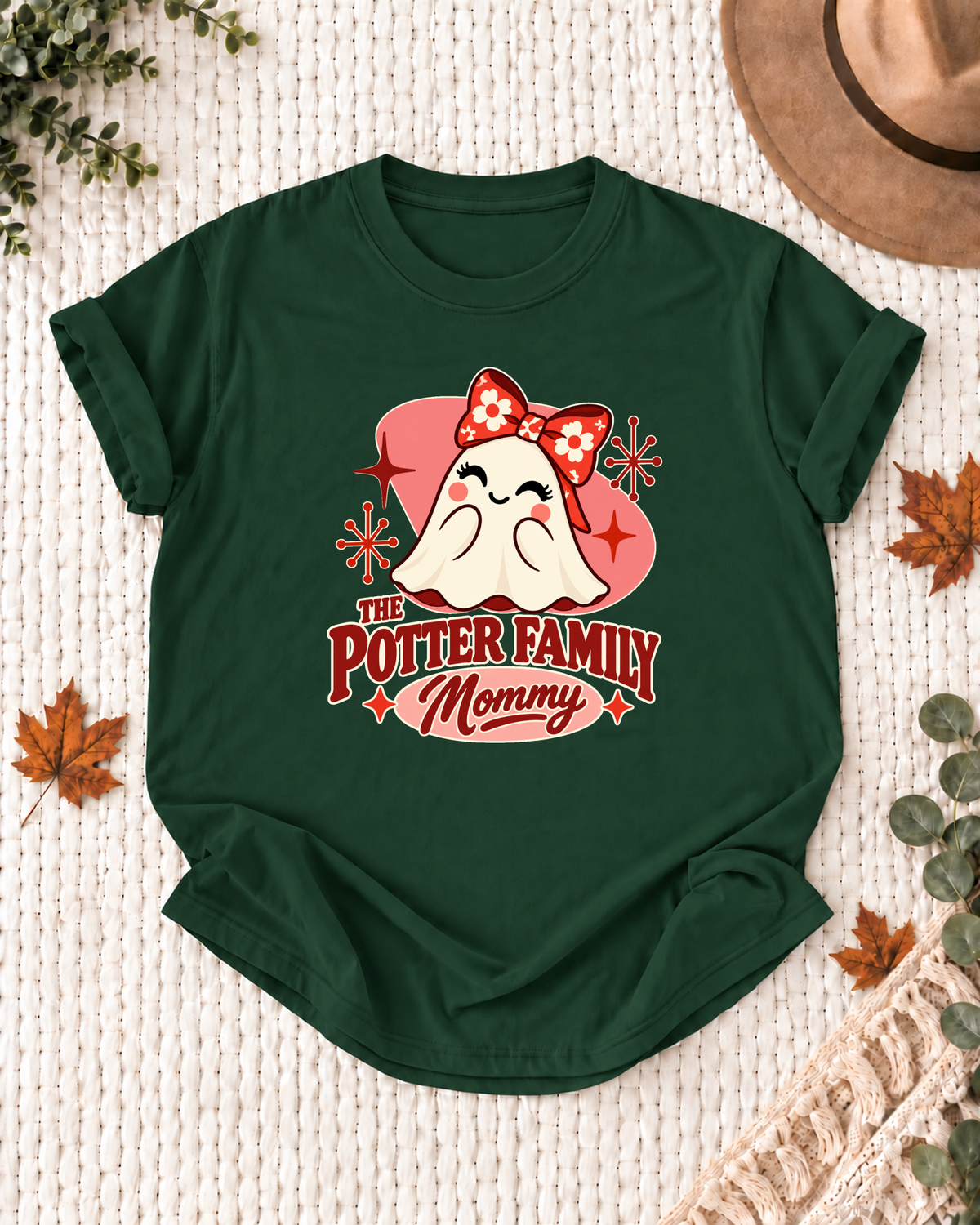 Mommy's Dark Green personalized Halloween shirt mockup with a mid-century ghost with a red bow and atomic starbursts, sample family lettering, and the role label.