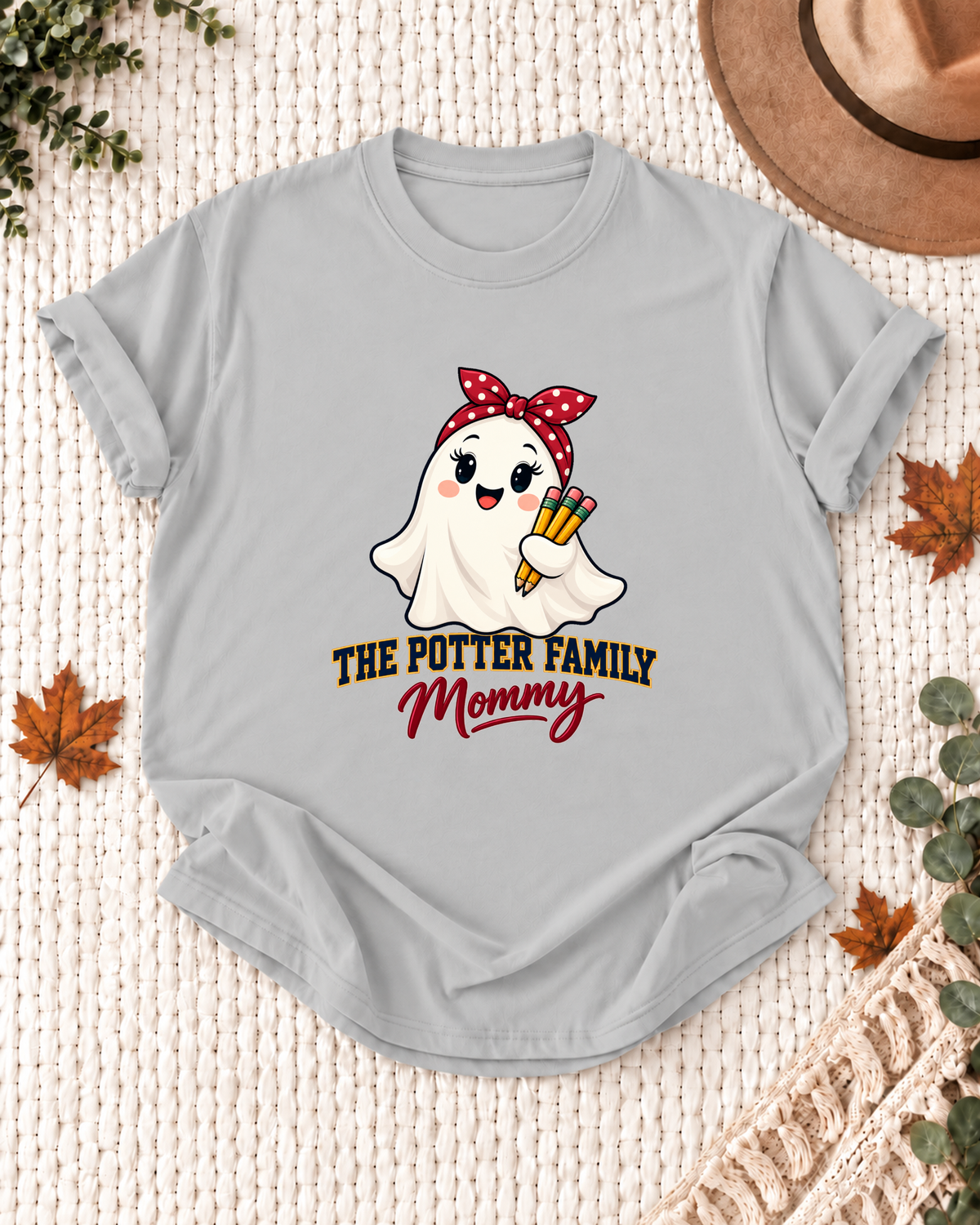 Mommy's Ash Grey personalized Halloween shirt mockup with a schoolhouse ghost with a school bow and book details, sample family lettering, and the role label.