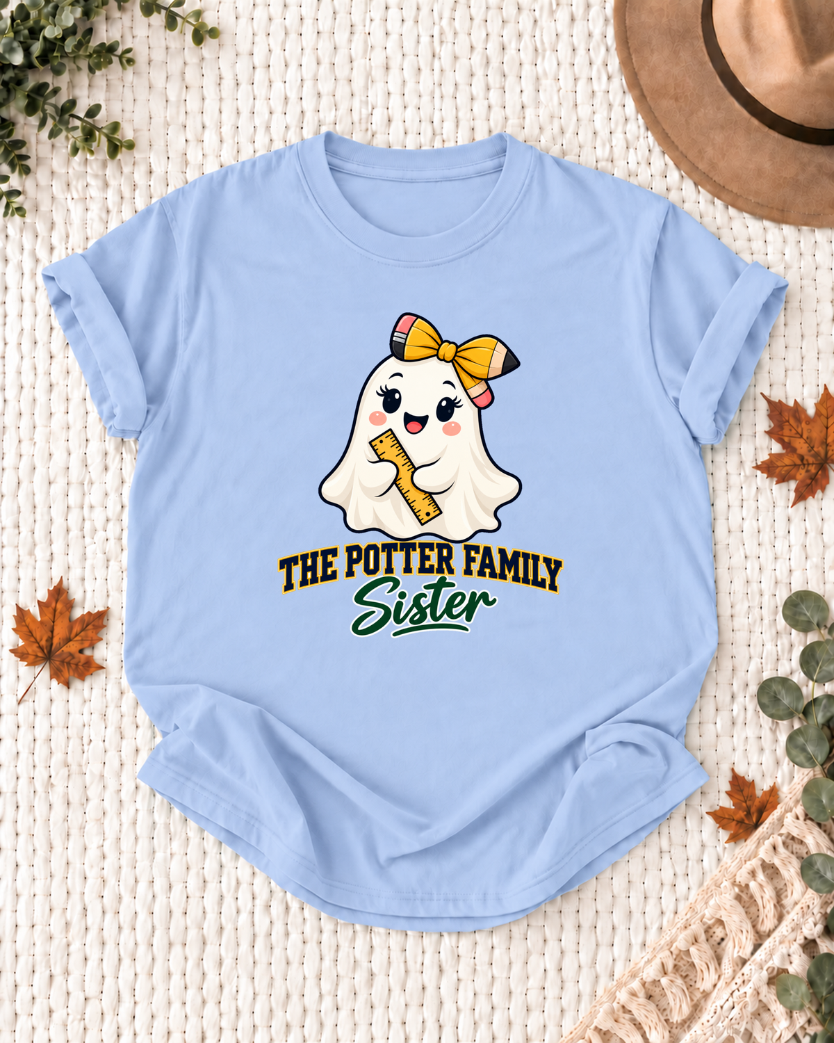 Sister's Light Blue personalized Halloween shirt mockup with a schoolhouse ghost with a bow, ruler, and book details, sample family lettering, and the role label.