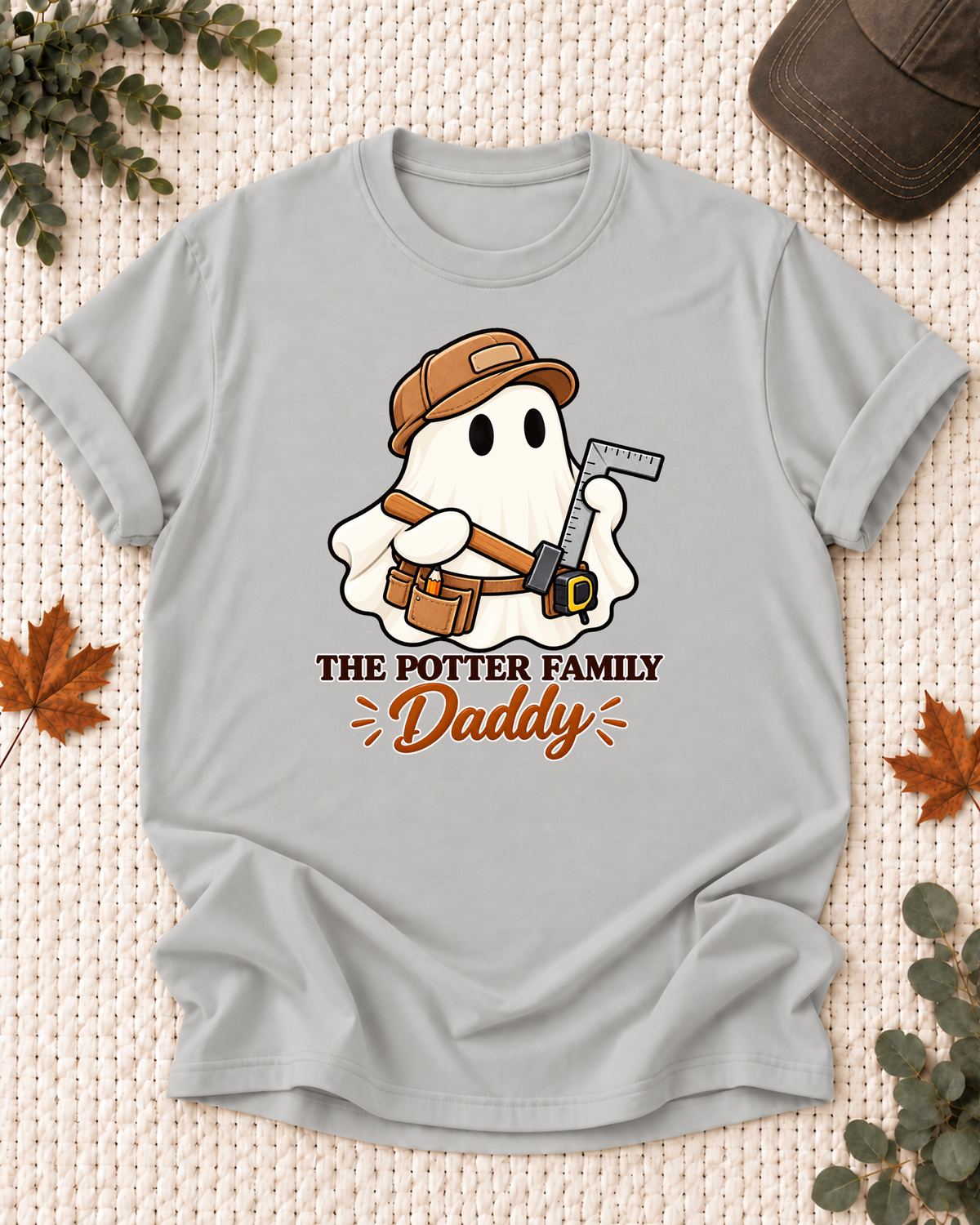 Daddy's Ash Grey personalized Halloween shirt mockup with a carpenter ghost with a saw and tool belt, sample family lettering, and the role label.