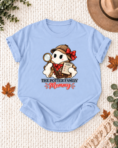 Mommy's Light Blue personalized Halloween shirt mockup with a detective ghost with a magnifying glass and clue details, sample family lettering, and the role label.